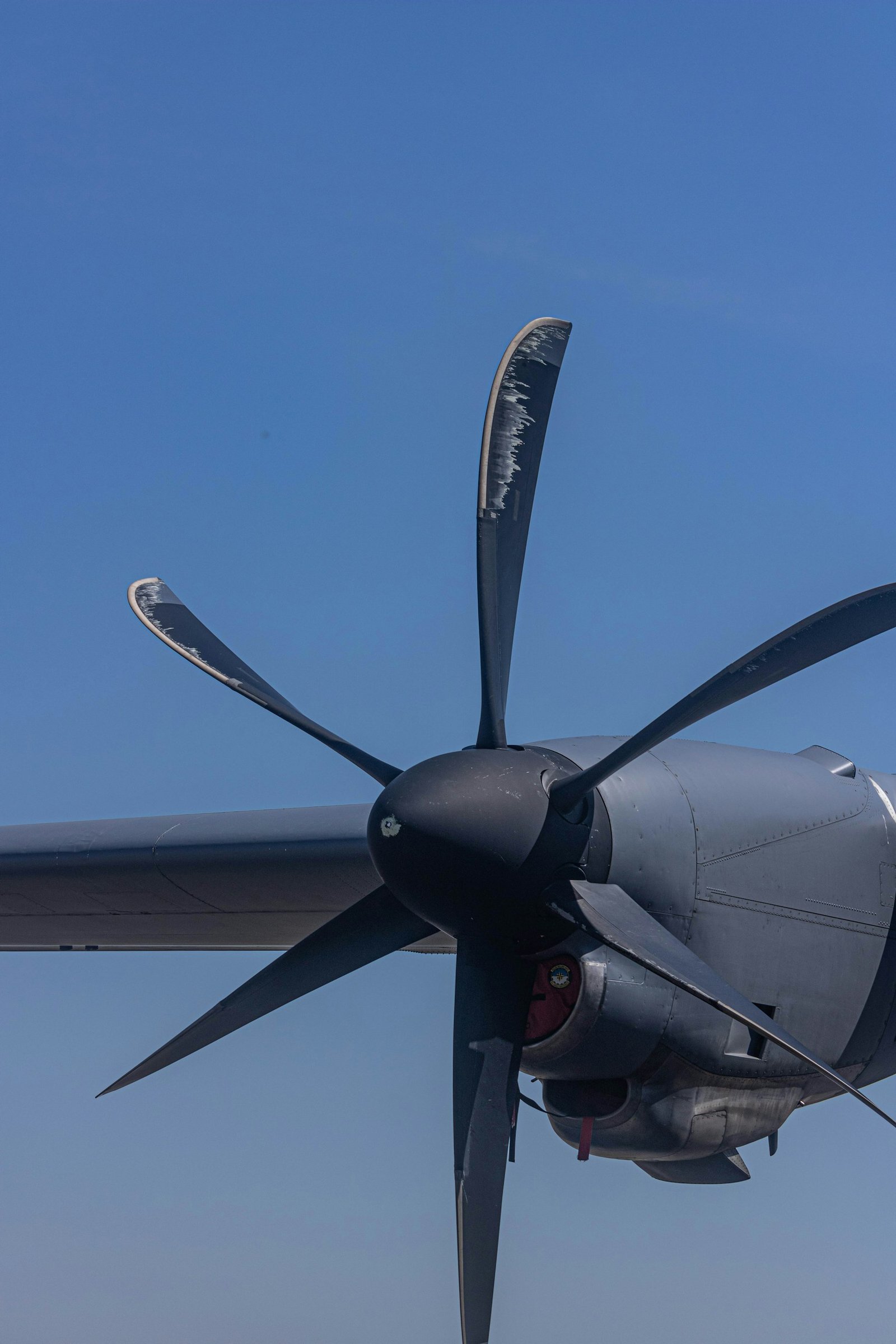 Hélice de uma aeronave fotografada em detalhe contra o céu azul.