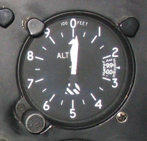 Foto real de um altímetro aeronáutico no painel da aeronave.